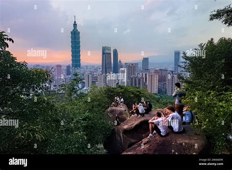 Tourists watching sunset from Elephant Mountain overlooking Taipei 101