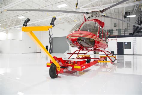traditional helicopter dolly beside modern chopper spotter unit on tarmac