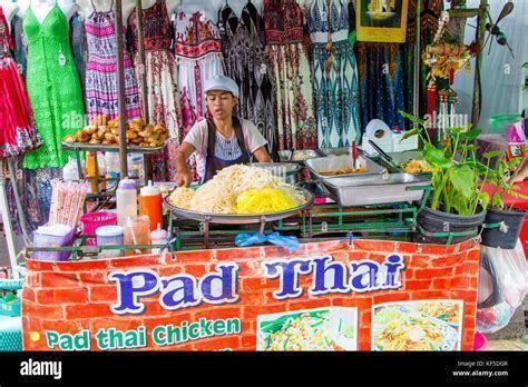 traditional Thai food stall with foreign tourists ordering Pad Thai
