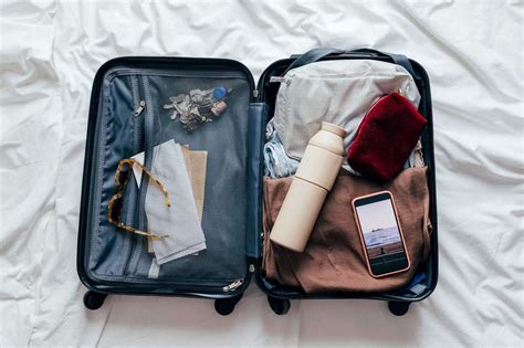 Traveler packing light into a carry-on suitcase for a low-cost flight