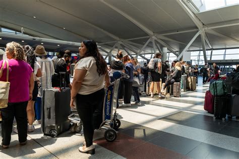 travelers waiting for standby flight status updates at a busy airport terminal