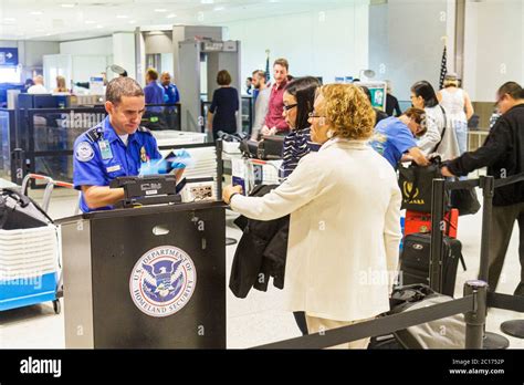 TSA checkpoint queue showing international travelers with clear plastic bags