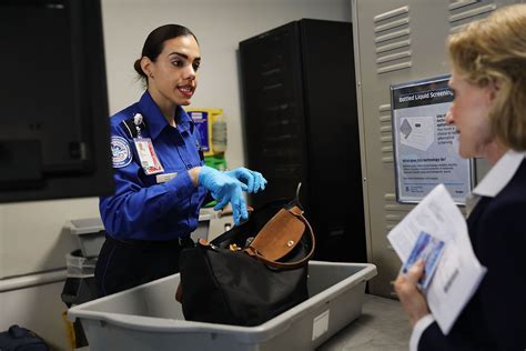 tsa officer inspecting portable charger during airport security screening