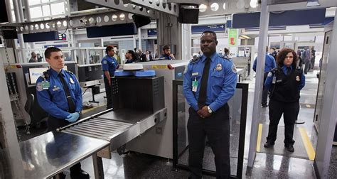 TSA security checkpoint with officer examining carry-on luggage