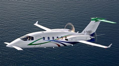 Twin-engine turboprop aircraft flying over mountains at 12,000 feet