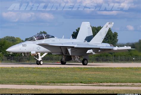 U.S. Navy carrier deck with both EA-18G Growler and F/A-18 Super Hornet lined up for takeoff