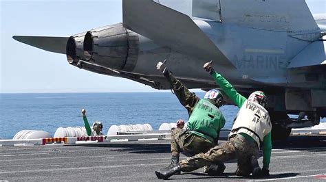 U.S. Navy fighter jet launching from aircraft carrier catapult deck