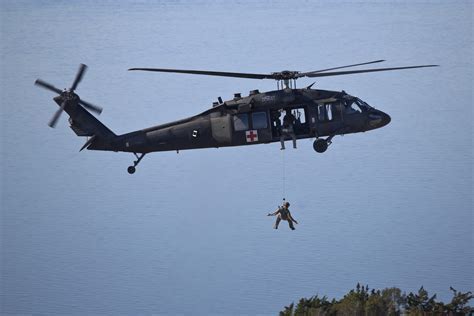 UH-60 Black Hawk with rescue hoist over rocky cliff