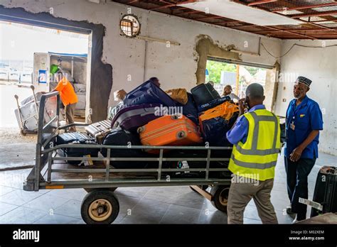 unclaimed baggage pile at zanzibar airport from delayed precision air flight