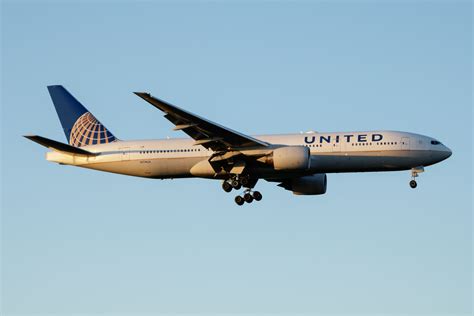 United Airlines Boeing 777-300ER landing at Dubai International Airport at dusk
