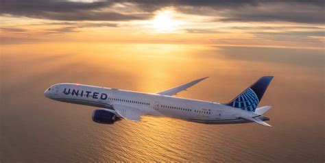 united airlines boeing 787 departing from newark against sunset skyline
