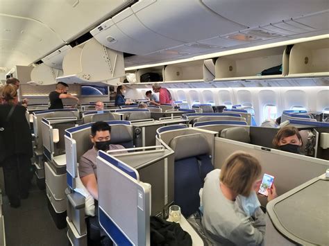 United Airlines crew restocking minimal beverage cart prior to departure from SFO
