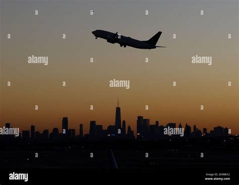 united airlines jet taking off from newark airport with city skyline in background