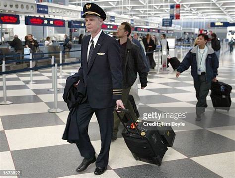 united airlines pilot and flight attendant walking across tarmac at los angeles airport during golden hour