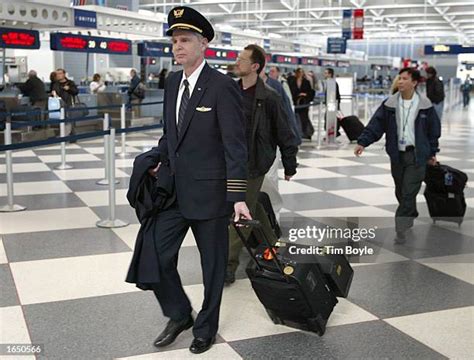 United Airlines pilots walking through international airport terminal in uniform