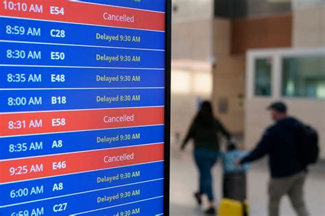 US airline passengers dealing with canceled flights at airport customer service counter