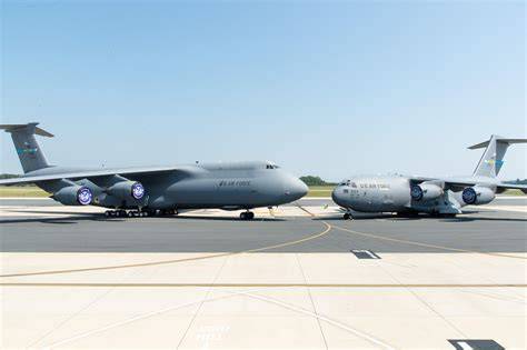 US military aviation lineup featuring a C-17 Globemaster III transport aircraft, F-15 Eagle fighter, EA-18G Growler, and T-45 Goshawk trainer