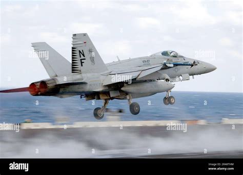 US Navy F/A-18 Super Hornet flying patrol over open ocean with visible markings