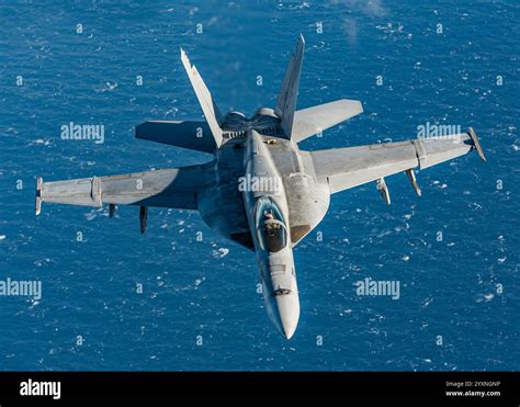 US Navy F/A-18E Super Hornet flying over the ocean during a high-performance training mission