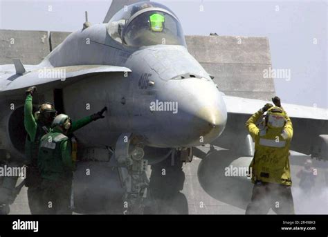 US Navy flight deck with multiple F/A-18 Super Hornets parked in rows
