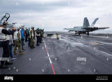 US Navy sailors working on a Ford-class carrier flight deck during long-duration deployment
