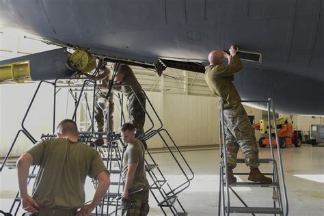 USAF maintenance crew servicing KC-135 engine hangar night
