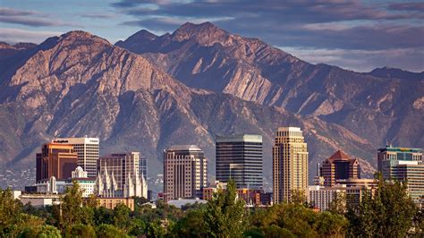 view of downtown salt lake city with mountains in background at sunrise