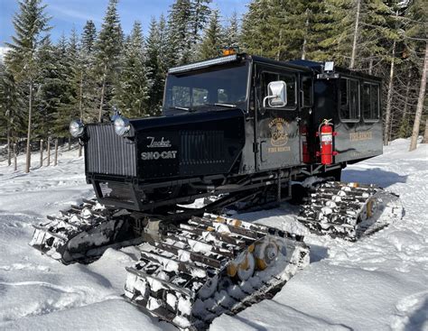 vintage Tucker Sno-Cat with military markings crossing snow field