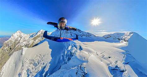 Wingsuit pilot soaring perilously close to jagged rock formations in Superflight