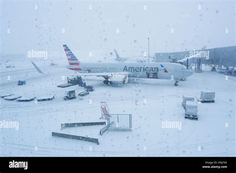 winter travelers boarding american airlines at regional snow-covered airport gate