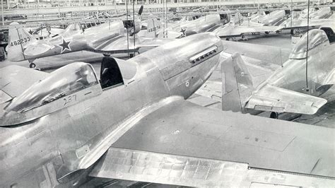 WWII era P-51 Mustang in assembly line with green zinc chromate coating on fuselage panels
