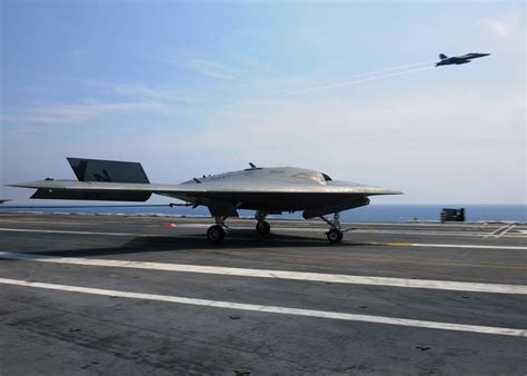 X-47B and F/A-18 Hornet lined up together on aircraft carrier deck