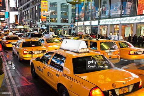yellow New York City taxi pulling up in front of JFK terminal during early morning light