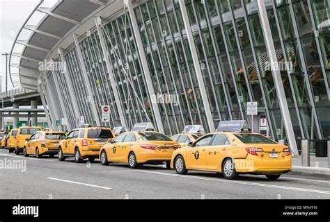 Yellow NYC taxi cab with JFK airport signage in background